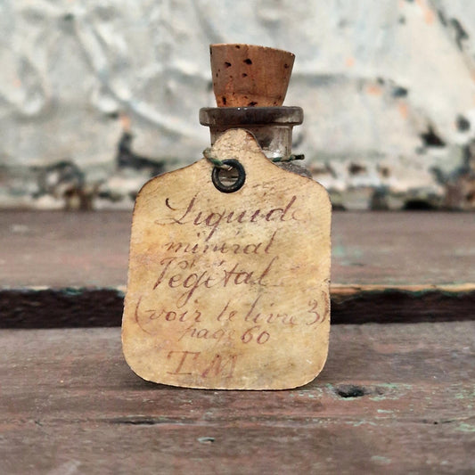 Flacon avec étiquette manuscrite « Liquide minéral végétal » (f37)