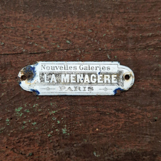 Plaque émaillée « La Ménagère - Nouvelles Galeries, Paris »