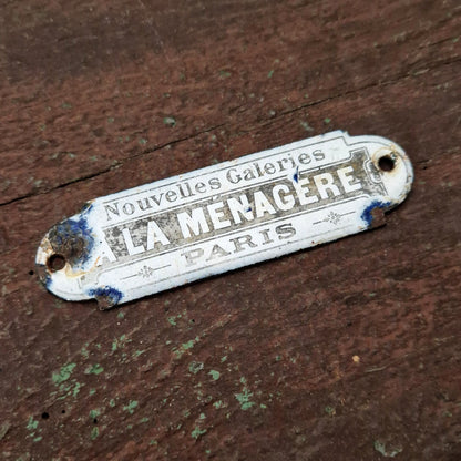 Plaque émaillée « La Ménagère - Nouvelles Galeries, Paris »